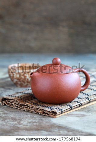 Traditional chinese tea ceremony accessories: tea pot, cup and green tea on the wooden table, selective focus on pot