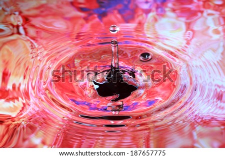 Photo art, Water drop and circles on on the water, colorful background in orange and purple colors, selective focus on drop