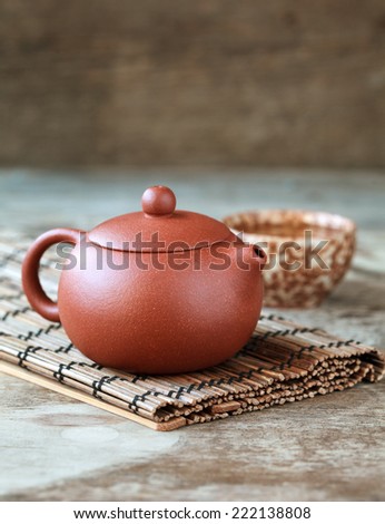 Traditional chinese tea ceremony accessories: tea pot, cup and green tea on the wooden table, selective focus on pot