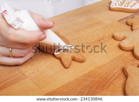 Decorating gingerbread cookies (rabbit) with white icing, selective focus and place for text