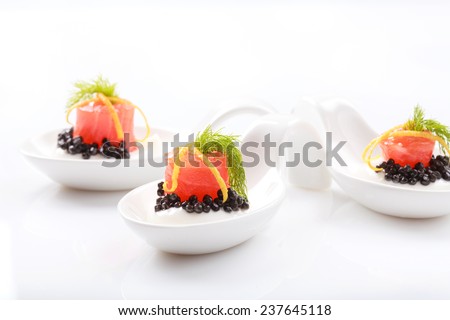 Appetizers in portion spoons of cream cheese, natural sturgeon black caviar, red salted salmon and dill on white table. Selective focus and place for text