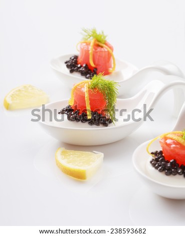 Appetizers in portion spoons of cream cheese, natural sturgeon black caviar, red salted salmon and dill on white table. Selective focus and place for text