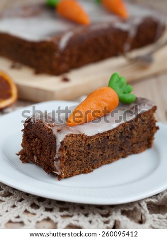 A piece of carrot cake with nuts, decorated with marzipan carrots. Selective focus