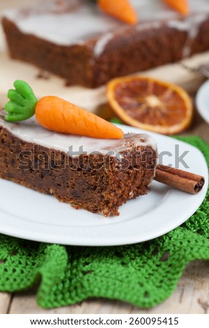 A piece of carrot cake with nuts, decorated with marzipan carrots. Selective focus