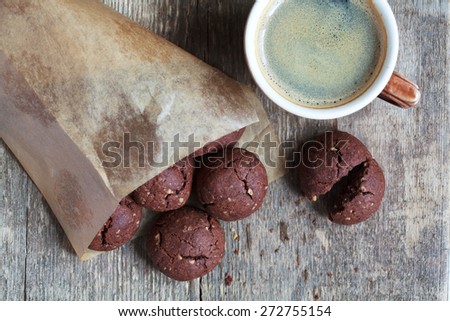 Italian chocolate cookies with walnuts and a cup of coffee on a wooden table, rustic style, selective focus