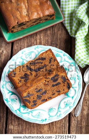 Cake with prunes and almond flour on a wooden table with a green cloth, selective focus