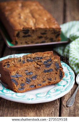Cake with prunes and almond flour on a wooden table with a green cloth, selective focus