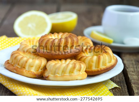 Homemade yellow lemon cakes on wooden table. Selective focus.