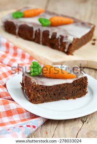 A piece of carrot cake with nuts, decorated with marzipan carrots, selective focus