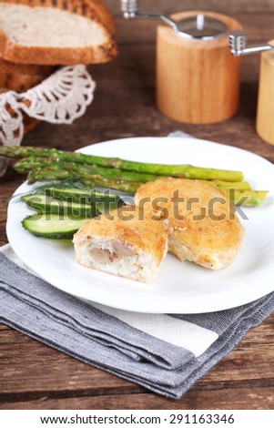 Traditional Russian cuisine - homemade fish patties (zrazy) stuffed with cod liver on a wooden table. Rustic style and selective focus.