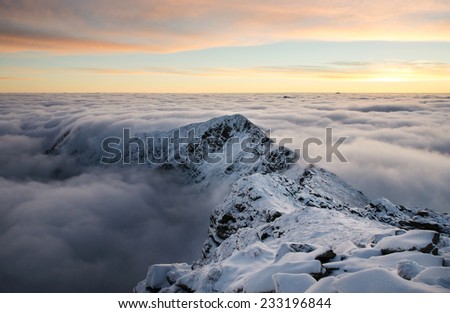 Spectacular mountain sunrise in winter time with orange sky and ice rocks