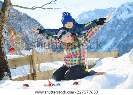 Happy family is playing airplane outside in a Alpine village