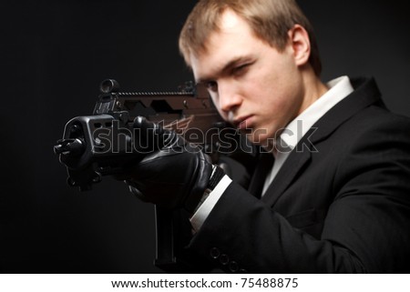 Man with gun over gradient gray. Focused on gun