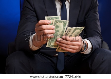Businessman counts money in hands.