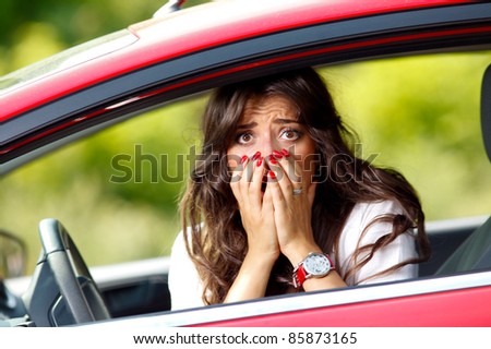Young pretty scared woman in the car