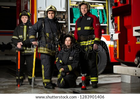 Image of three firemen men and woman near fire truck