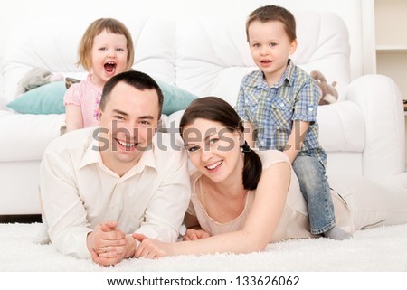 Family Lying On A Carpet In Their Living Room
