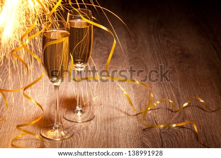 Flutes of champagne in holiday setting on the wooden background , Closeup.