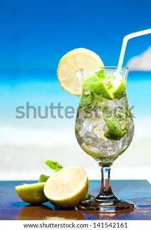 Mojito cocktail with lime and mint against sea background