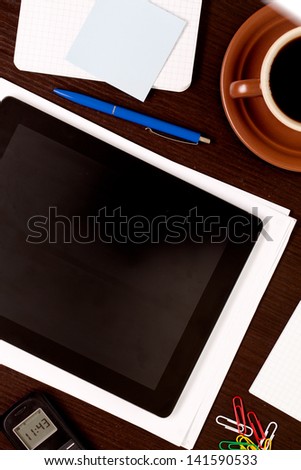 Workplace with blank digital tablet, paper, pen and cup of coffee on work table. Above view shot.