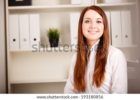 Close-up portrait of young businesswoman in bright office