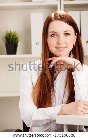 Close-up portrait of young businesswoman in bright office