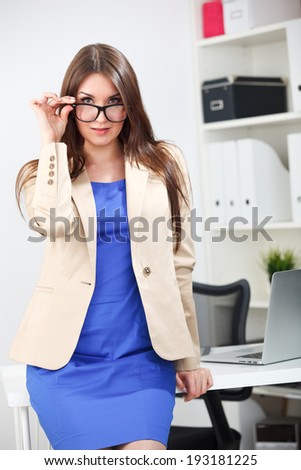 woman standing in blue dress and jacket at office