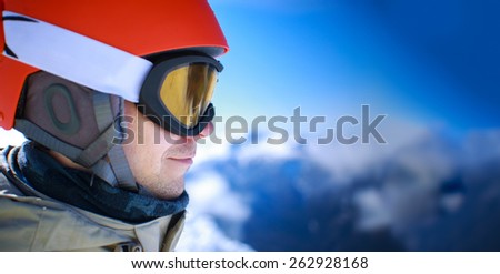 Close up of the ski goggles of a man with the mountains at background