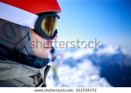 Close up of the ski goggles of a man with the mountains at background