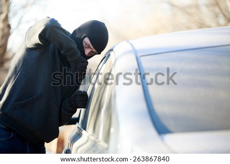 Thief stealing automobile car at daylight street in city