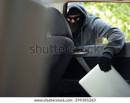 Car theft - a laptop being stolen through the window of an unoccupied car.