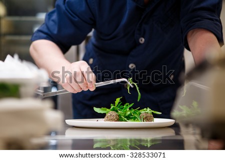 Chef in hotel or restaurant kitchen cooking, only hands
