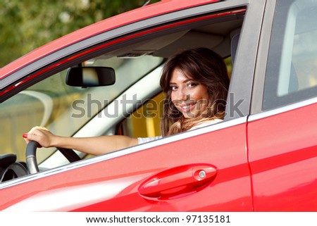 Young pretty woman in the red car