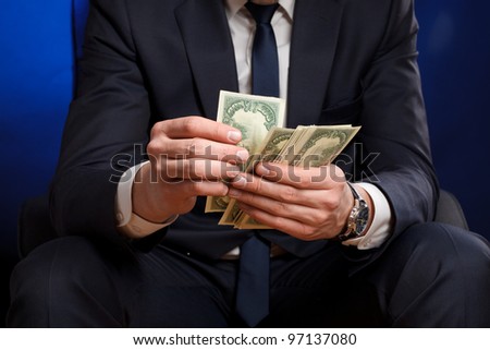Businessman counts money in hands.