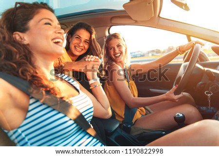 Three female friends enjoying traveling in the car.