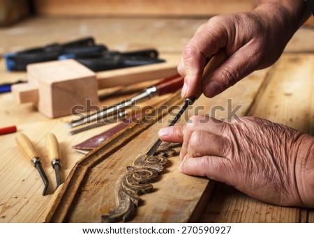 The hands of an senior carpenter restoring old furniture, Close-up.