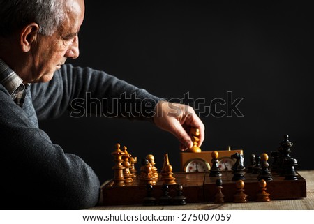 Senior man thinking about his next move in a game of chess