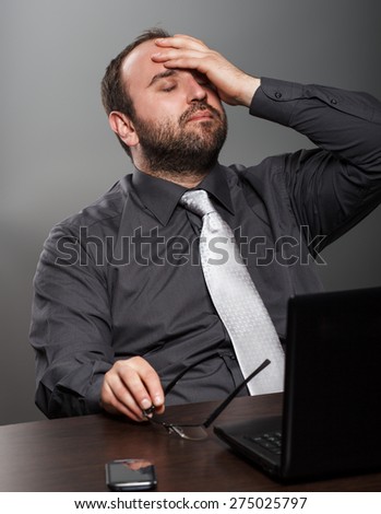 Businessman exhausted at work in his office.