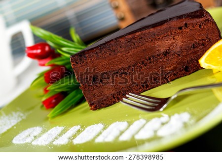 A slice of rich dark chocolate cake with word calories written on the plate.