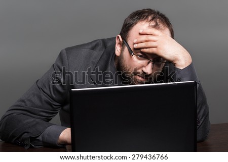Frustrated businessman working on laptop
