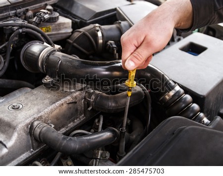 Mechanic checks the oil on a car being repaired