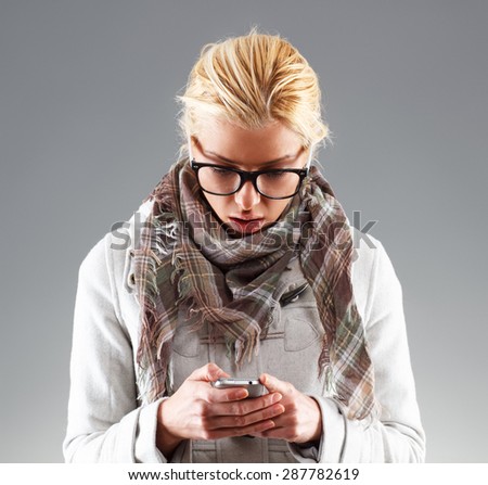 Portrait of young woman looking surprised while reading text message