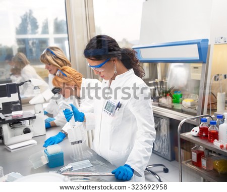Photo of three real female scientists researching in laboratory.