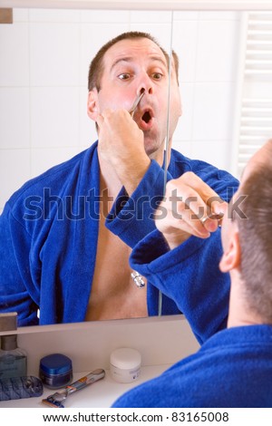 Man cuts hair in the nose
