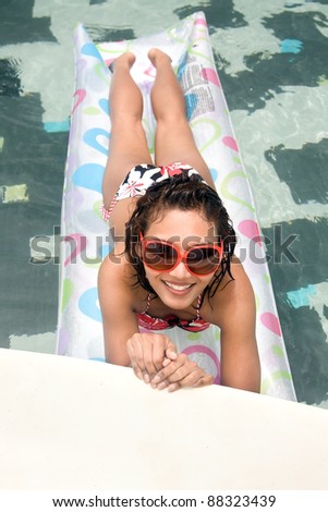Young woman on air bed in the pool