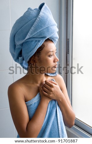 Young woman wrapped towel in bathroom
