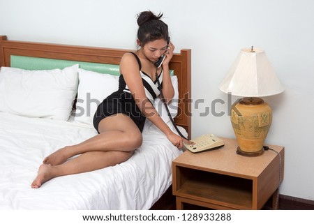 woman calling from the phone on the bed