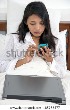 woman doing electronic communication in bed