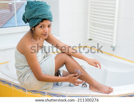 young woman creams her leg