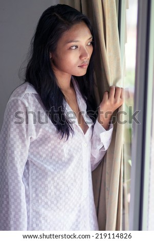 young woman watched from window